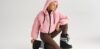Nő rózsaszín kabátban, barna leggingsben és Moon Boot hótaposóban