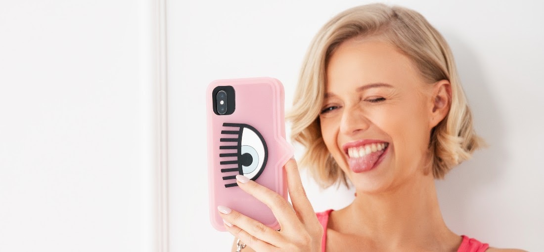 Egy nő rózsaszín szilikon telefontokkal a kezében