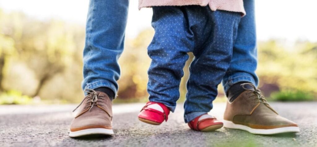 Szülő gyermekével piros és barna cipőben