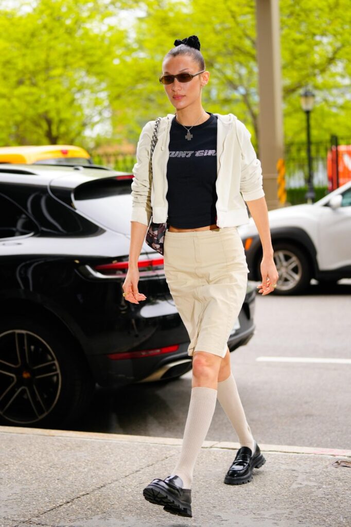 Egy modell kockás mini szoknyában, fehér zokniban és elefántcsont színű orrú mokaszinban