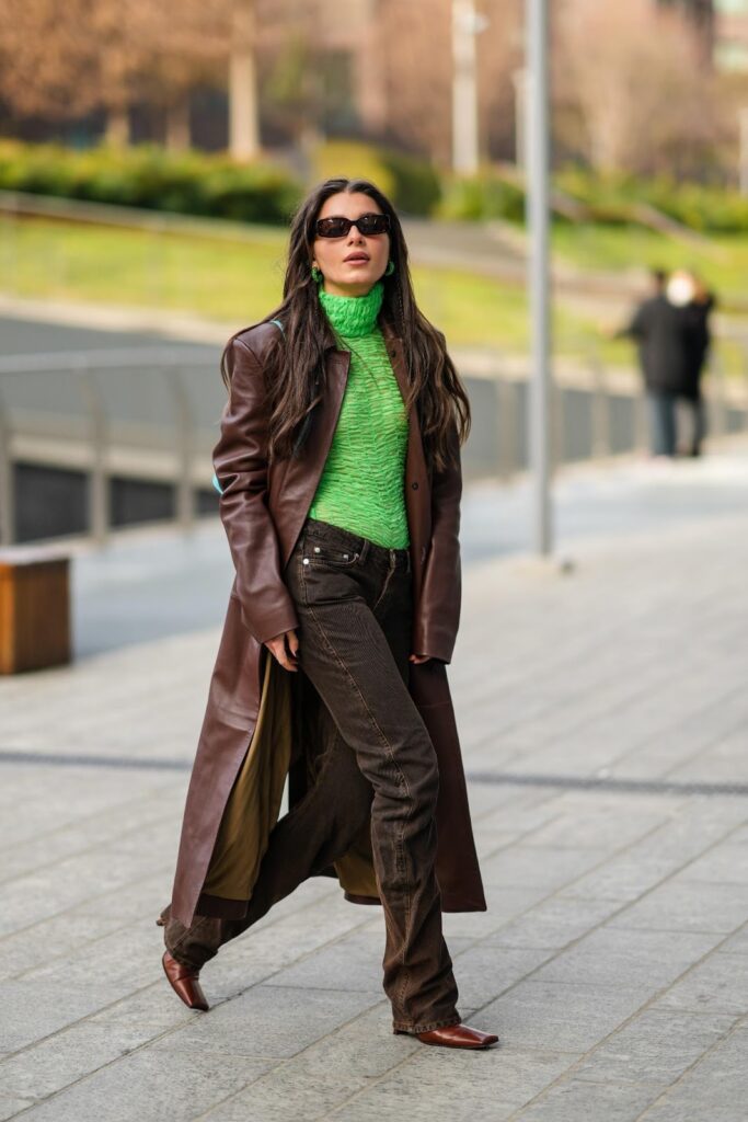 Nő barna outfitben és zöld garbó pulóverben