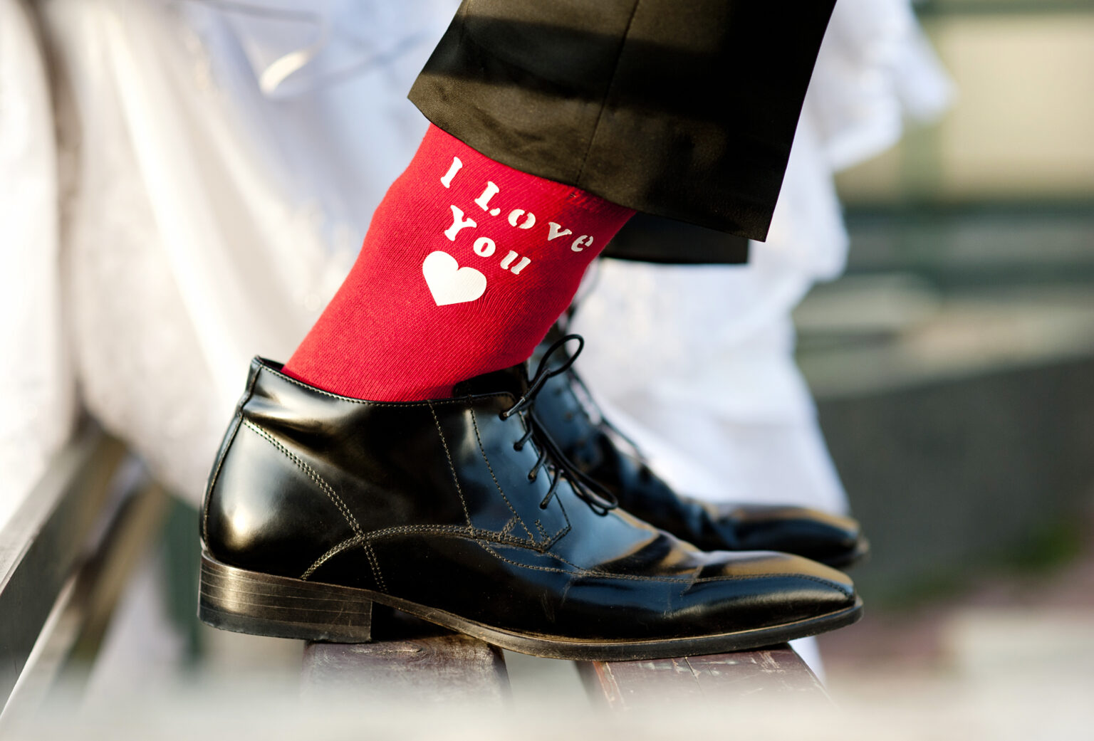Völegény alkalmi félcipőben és piros, "I love you" feliratos zokniba